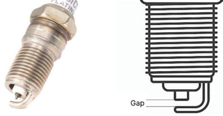 Why should you vacuum around a spark plug before removing it?